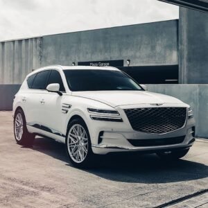 Who makes Genesis cars: white Genesis luxury SUV with crest grille and two-line headlights
